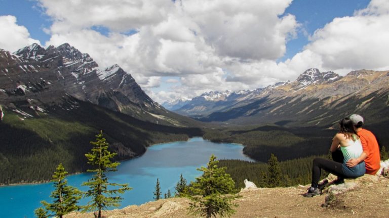 Una pareja contemplando un lago de color azul en Canadá