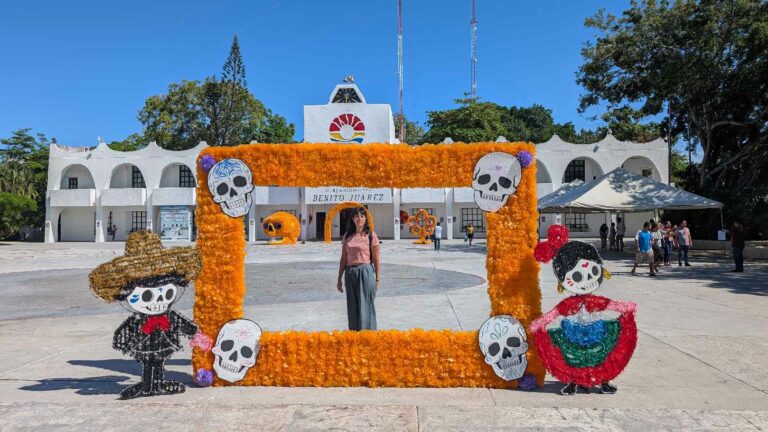 Chica en Cancún posando con un cuadro mexicano hecho con flores